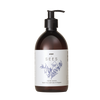 SEES x Moomin Hand Wash; ruskea muovinen pumppupullo mattapinnalla pystyssä valkoista taustaa vasten; pullossa musta pumppuannostelija ja painettuja kasvikuvituksia etuetiketissä; etikettitekstissä SEES HAND WASH, Noble Forest, Cedar & Bergamot; groteskityypografia läpi tuotteen; ei ihmisiä tai muita esineitä kuvassa.