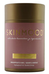 SkinMood Imukuppisarja Kuivakuppaukseen; lieriömäinen astia tekstillä "SKINMOOD", kultainen kansi ja vaaleanpunainen etiketti suomen- ja ruotsinkielisin tekstein; näkyvissä neljä läpikuultavaa silikonikuppia eri kokoisina; etiketti modernia groteskifonttia; kaikilla esineillä sileä, kiiltävä pinta; tausta valkoinen, ei ihmisiä tai käsiä kuvassa.