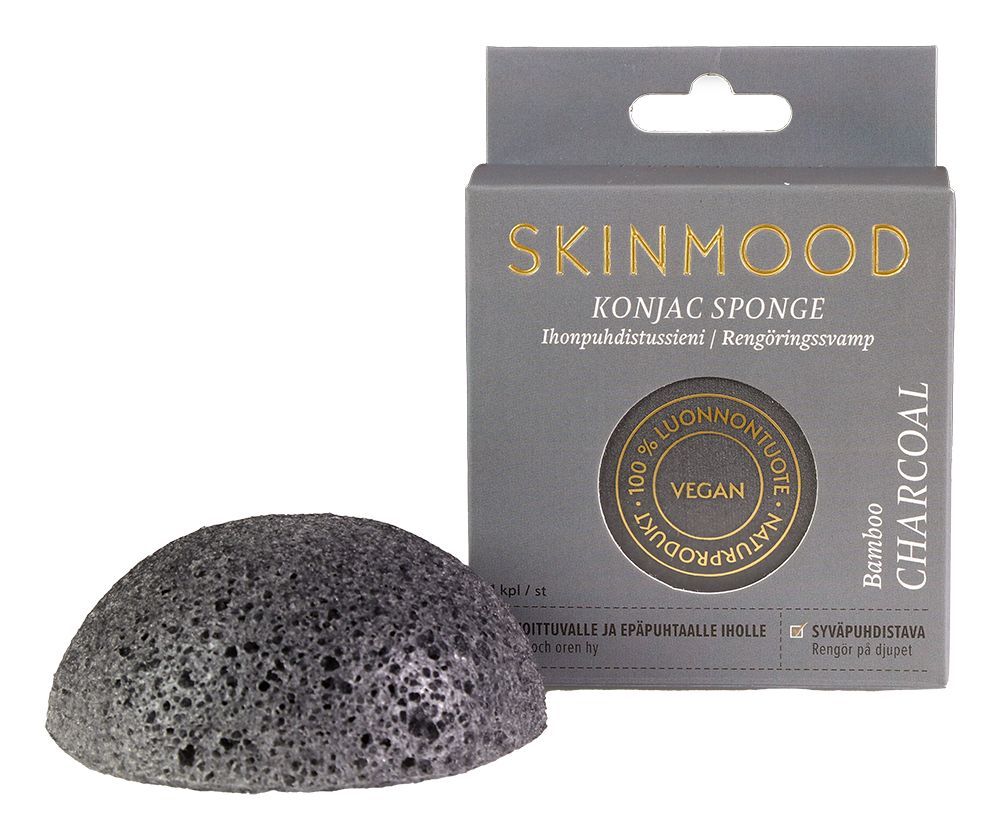 SkinMood Magical Konjac Sponge Bamboo Charcoal -pesusieni; musta, pyöreä ja mattapintainen sieni pystyssä suorakulmaisen pakkauksensa edessä; pakkauksessa kultaista ja valkoista tekstausvapaata tekstiä sekä pyöreitä vegaani- ja luonnontuotemerkkejä; molemmat kuvattu valkoista taustaa vasten, ei ihmisiä tai käsiä näkyvissä.