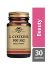 Solgar L-Kysteiini -pullo, ruskea lasi, kiiltävä kultainen kierrekorkki; musta-kultainen antiikva- ja groteskiteksti, "500 mg Free Form", vaaleanpunainen "Beauty"-laatikko ja harmaa "30 capsules"-laatikko vieressä