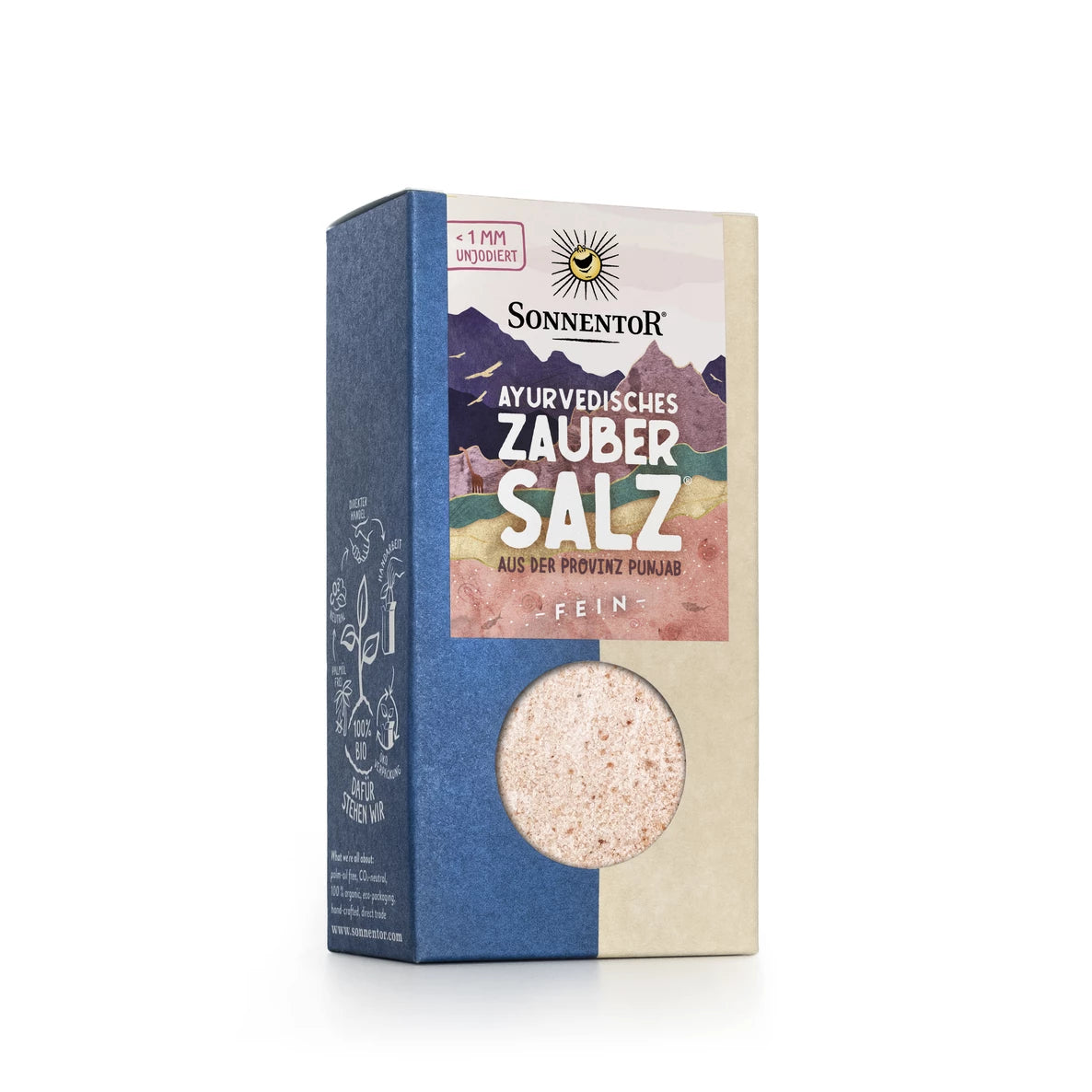 Laatikko Sonnentor Ayurvedic Zauber Salz -hienoa vaaleanpunaista suolaa Punjabista, pyöreällä läpinäkyvällä ikkunalla paljastaen Himalajan suolan sisällä. Suorakulmainen pahvipakkaus on mattapintainen ja siinä on painettuja vuorikuvituksia sinisenä ja beigenä. Teksti on saksaksi pääteviivattomalla fontilla. Ihmisiä tai käsiä ei näy. Tausta on neutraali ja tekstuuriton, kuva on edestä näyttäen koko pakkauksen pystyssä.