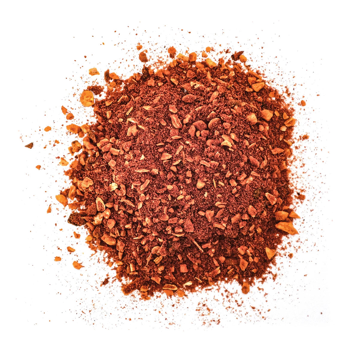 Kasa hienoksi jauhettua punaruskeaa paprikaa pienine epätasaisine paloineen on siroteltu valkoiselle taustalle. Paprika on löyhää ja pakkaamatonta, mattapintaista, ilman näkyvää pakkausta tai etikettejä. Tausta on pelkistetty ja valkoinen, ja kuva tarjoaa suoran näkymän ylhäältä. Ihmisiä tai typografiaa ei näy.