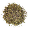 Kasa kuivattuja, silputtuja vihreitä yrttejä, todennäköisesti timjamia, on siroteltu valkoiselle taustalle. Yrttien palaset ovat pieniä ja epäsäännöllisiä muodoltaan. Pakkausta tai etikettejä ei näy. Yrttien pinnan viimeistely on matta. Ihmisiä tai käsiä ei näy kuvassa. Kyseessä on ylhäältä otettu kuva tarkasti tuotteeseen keskittyen pelkistetyssä ympäristössä.