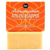 Sopo Aurinkoinen Aito Palasaippua; oranssi saippuapala mattapinnalla lepää suorakaiteen muotoisen laatikon vieressä; laatikossa teksti "Aurinkoinen Aito Palasaippua" lihavoiduin groteskisuuraakkosin; pakkaus pääosin valkoinen ja oranssi, pienempi suomenkielinen teksti kuvaa tuoksun appelsiiniksi ja vetiveriksi; molemmat tuotteet yksinkertaisella, neutraalilla taustalla tasaisessa valaistuksessa; ei ihmisiä eikä käsiä näkyvissä.
