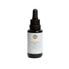 Sopo Metsäbiomi Balance Oil; pieni tummalasinen pullo mattapinnalla ja mustalla tippakorkilla seisoo pystyssä tasaisella valkoisella taustalla; etiketti valkoinen selkeällä mustalla groteskitekstillä: ”Balance Oil with Forest Biome by Sopo”; ei ihmisiä tai käsiä; lähikuva tuotteesta, joka tuo mieleen metsäbiomin tunnelman.