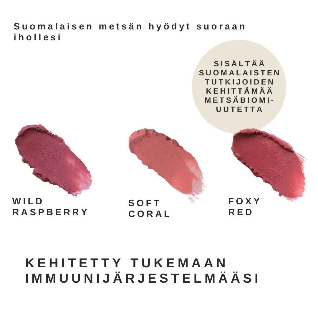 Sopo Sävyttävä Metsäbiomi Huulivoide & Poskipuna; kolme huulipunanäytettä nimillä Wild Raspberry, Soft Coral ja Foxy Red aseteltuna tasaiselle pinnalle; sivelyjäljet kermaisia puolikiiltävällä pinnalla; suomenkielisessä tekstissä mainitaan immuunihyödyt ja suomalaisten tutkijoiden hyödyntämät suomalaiset metsäainesosat villimarjauutteineen ihonhoitoon; ei pakkausta eikä ihmisiä näkyvissä; tausta neutraali, kuva ylhäältä.