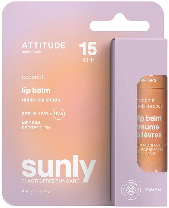 Sunly by Attitude Huulivoide SPF15; persikan- ja violetinvärinen pakkaus ATTITUDE Sunly -kookoshuulivoidetta, SPF 15, keskitasoinen suoja, vegaaninen ja muovivapaa, tuote osittain näkyvissä sivuikkunasta; pakkauksessa korostetaan laajakirjoista UVB+UVA-suojaa; laatikko mattapinnalla ja suorakulmainen; lihavoitu groteskikirjasin kontrastivärein; ei ihmisiä tai rekvisiittaa kuvassa, pelkistetty tausta, lähikuva.