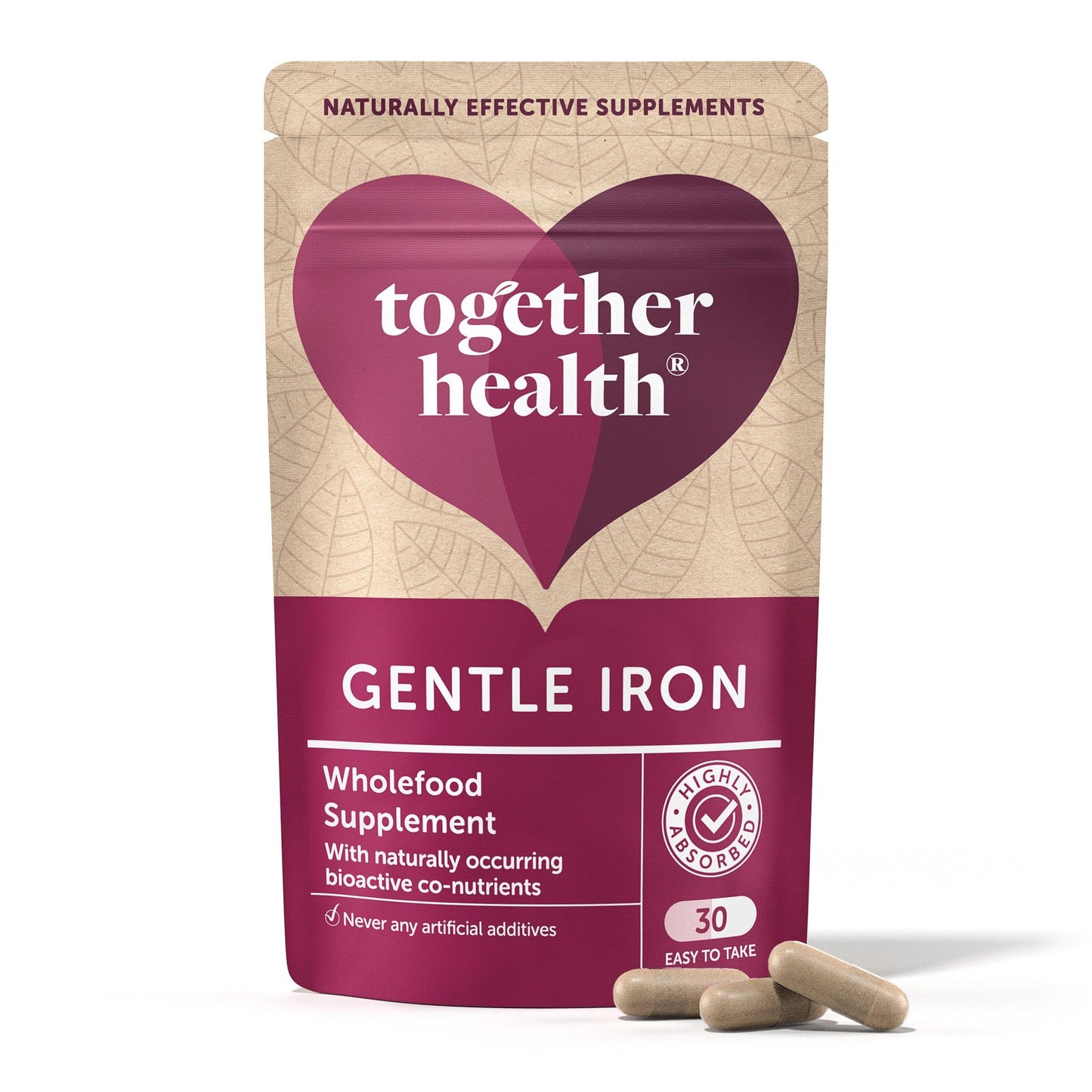 A matte pouch labeled Together Health Gentle Iron Wholefood Supplement with a heart design is shown upright beside three beige capsules. The packaging is light-colored, rectangular with a seal at the top, and features simple sans-serif typography. Only label text legible: product name and brief supplement information. Plain white background, no people or objects present.