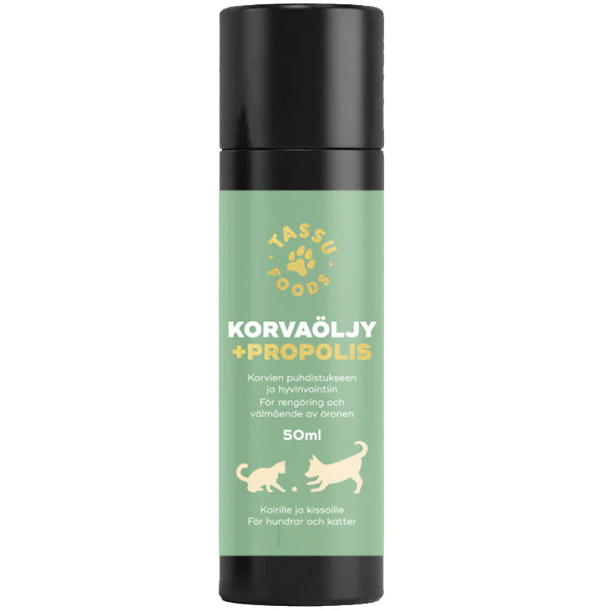 Tassu Foods Korvaöljy + Propolis; pullo Tassu Foods Korvaöljy + Propolis -luonnollista korvaöljyä koirille ja kissoille, vihreä etiketti, koko 50 ml, esittää koiran ja kissan siluetit sekä tekstiä suomeksi ja ruotsiksi; pullo lieriömäinen mattapinnalla; logo ja tuotenimi yksinkertaisin groteskifontein; kuva otettu valkoisella taustalla, ei ihmisiä tai käsiä näkyvissä.