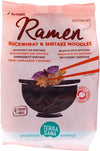 TerraSana Luomu Ramen Tattari & Siitake Nuudelit, pakkaus tattari- ja siitakenuudeleille, näyttää mustan kulhon syömäpuikkoineen pitelemässä nuudeleita; etusivulla mattapintainen pakkaus valokuvalla annoksesta; tekstissä "gluteeniton", "luomu" ja "4 tattarista valmistettua ramen-nuudelikakkua"; groteskifonttia käytössä; ei ihmisiä eikä käsiä näkyvissä, valkoinen tausta, tuote keskitettynä.