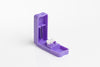 Violetti tablettileikkuri avoimella kannella näyttää terävän metalliterän kiinnitettynä yläosaan sekä pyöreän valkoisen tabletin, joka on jaettu tasan kahtia alaosassa; leikkuri valmistettu sileästä, läpikuultavasta muovista kiiltäväpinnalla ilman näkyvää tekstiä tai brändäystä; kuva otettu yhtenäisellä valkoisella taustalla täydessä tuotekuvassa.