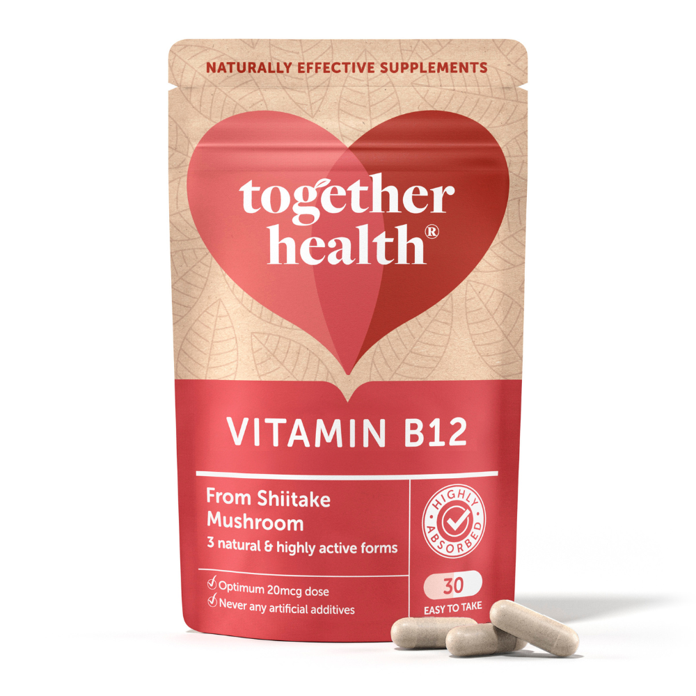 Punainen ja beige joustava pakkaus Together Health Vitamin B12 shiitakesienestä seisoo pystyssä tasaisella alustalla. Kolme luonnonvalkoista vegaanista kapselia on aseteltu pakkauksen eteen. Mattapintainen pakkaus on suorakulmainen pyöristetyin kulmin ja siinä on lihavoitua tummaa pääteviivatonta tekstiä. Luettavat viestit viittaavat luonnollisiin ainesosiin, optimaaliseen annokseen ja 30 helposti otettavaan kapseliin. Pelkistetty tausta ilman näkyvää ympäristöä tai ihmisiä.