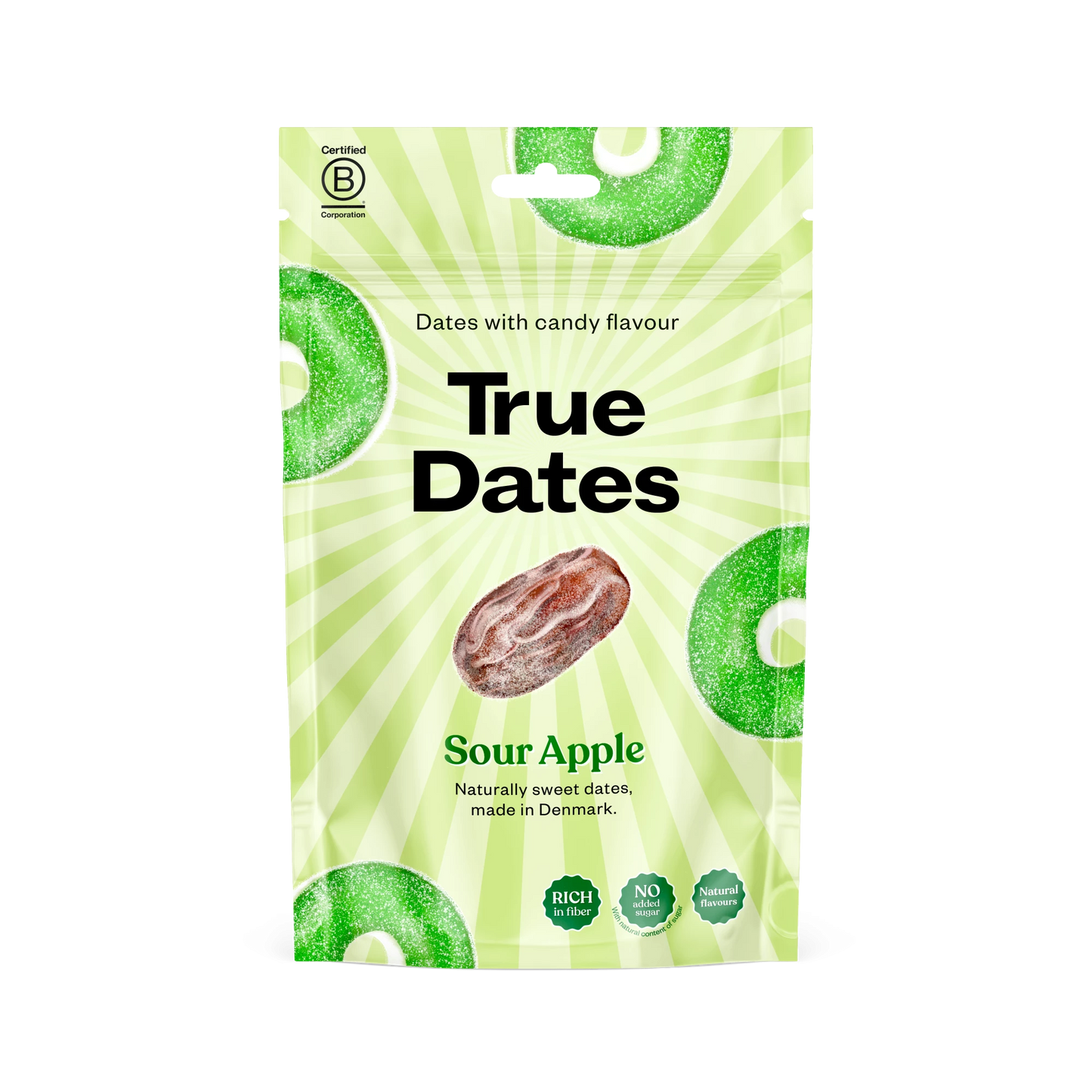 True Dates Kirpeä Omena; vihreä pussi, jossa lukee True Dates Sour Apple, keskellä taateli ja vihreitä omenanmakuisia karkkiviipaleita, tekstissä mainitaan karkin makuinen taateli; pussissa lihavaa groteskitekstiä tuote- ja makunimelle; pakkauksessa mainitaan myös ”Made in Denmark”, ”rich in fiber” ja ”candy-inspired”; kuva on pussista valkoista taustaa vasten, ei ihmisiä tai käsiä näkyvissä.
