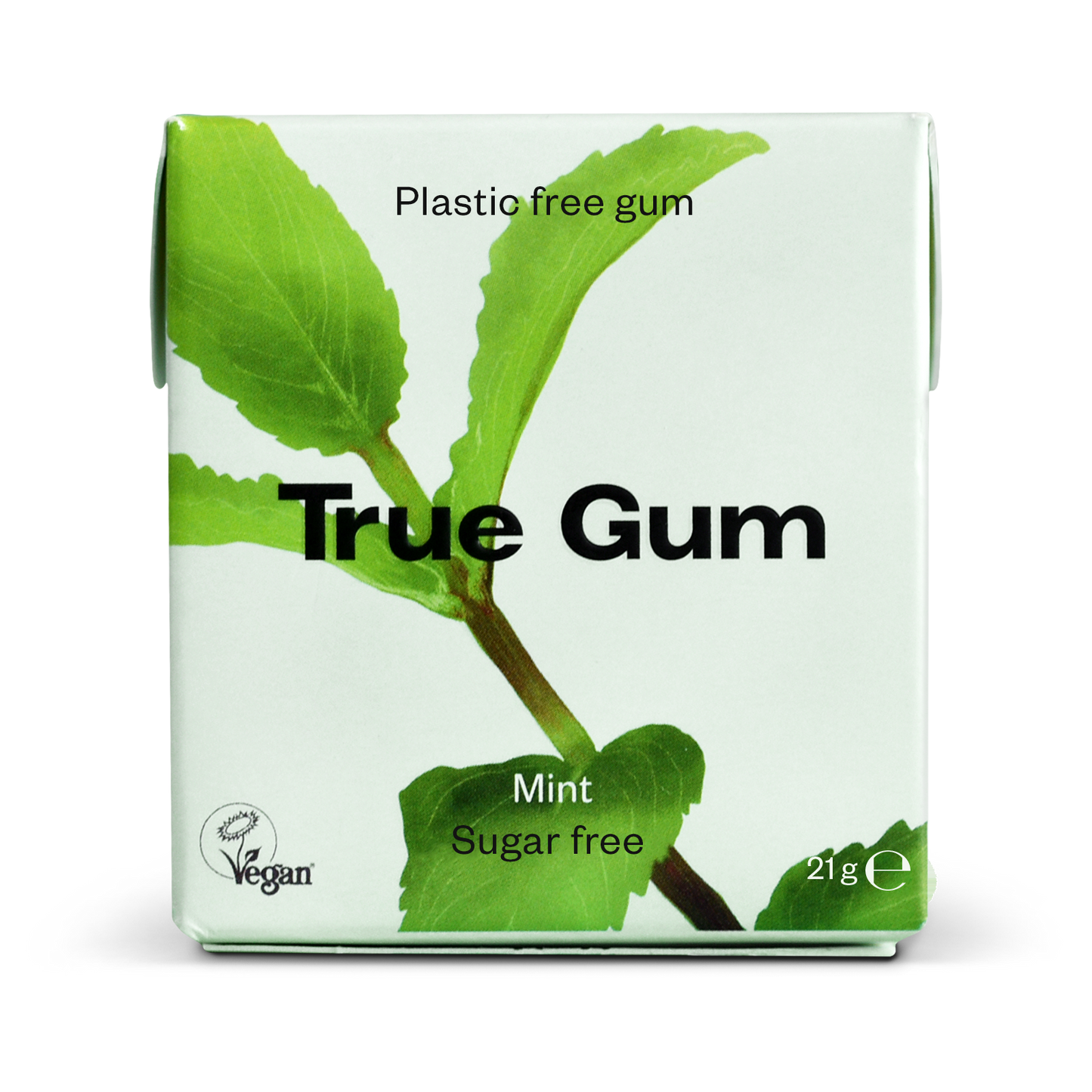 True Gum -pakkaus, merkintä muoviton ja vegaaninen, minttumaku, sokeriton, paino 21 g; suorakaiteen muotoinen pakkaus mattavalkoisella pinnalla ja vihreillä minttulehtikuvituksilla etusivulla; päätekstissä lihavoitu musta groteskikirjasin, lisämerkinnät kevyemmällä fontilla; ei ihmisiä tai käsiä näkyvissä; tausta valkoinen, kuvattu suoraan edestä silmän tasolta.