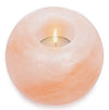 Round pink Himalayan salt candle holder with a glowing tealight inside, adding a warm and natural ambiance to any room. Solid, cylindrical form with smooth matte finish; translucent pink-orange mineral body. No visible labels or typography. Product is shown alone on a plain, light background in a centered product shot. No packaging, people, or actions are present.