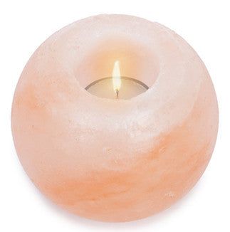 Round pink Himalayan salt candle holder with a glowing tealight inside, adding a warm and natural ambiance to any room. Solid, cylindrical form with smooth matte finish; translucent pink-orange mineral body. No visible labels or typography. Product is shown alone on a plain, light background in a centered product shot. No packaging, people, or actions are present.