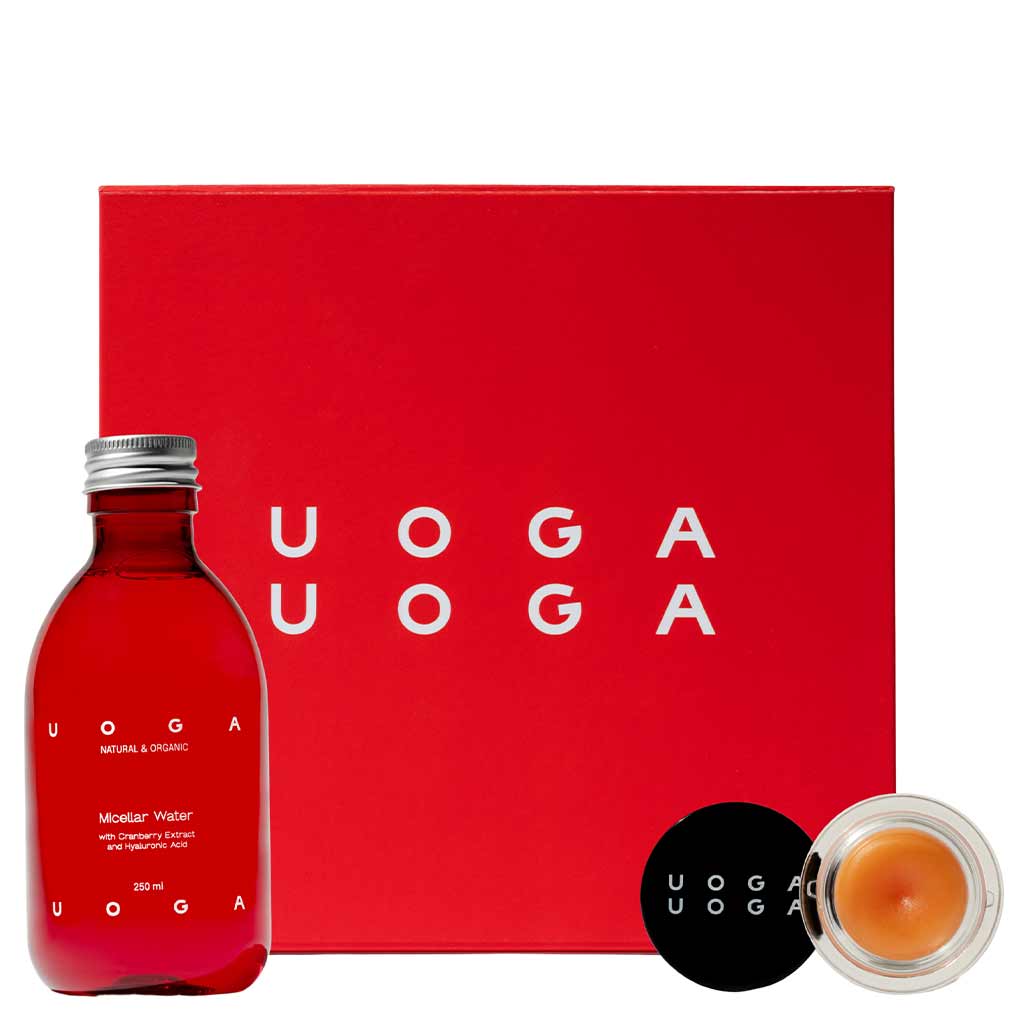 Uoga Uoga Gift Set No. 4; punainen Uoga Uoga -lahjapakkaus valkoisin tekstein, pullo micellar-vettä ja pieni pyöreä purkki luonnollista huulivoidetta mustalla kannella, molemmat merkitty Uoga Uoga, aseteltuna laatikon eteen; lahjapakkaus suorakaiteen muotoinen ja mattapunainen; micellar-vesipullo läpinäkyvä mustalla kannella; huulivoide pyöreämuotoinen; kaikissa pakkauksissa groteskitekstiä; ei ihmisiä tai taustaesineitä; studiokuva neutraalilla taustalla.