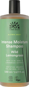 Urtekram Blown Away Wild Lemongrass Shampoo, 500 ml; pullo Urtekram Intense Moisture -shampoolle, Wild Lemongrass -laji, sisältää aloe veraa ja sitruunaruohouutetta, koko 500 ml; pullo lieriön muotoinen pumppuannostelijalla ja mattapinnalla; etiketti vihreä valkoisin ja keltaisin sans-serif-tekstein; kuvakkeet osoittavat vegaanisuutta ja sertifioituja luonnonmukaisia ainesosia; neutraali tausta, ei ihmisiä tai käsiä.