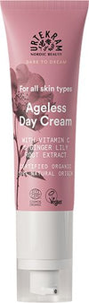 Urtekram Dare to Dream Ageless Päivävoide, tuubi ikääntymistä vastustavalle päivävoiteelle C-vitamiinilla ja inkiväärililjajuuriuutteella, merkitty kaikille ihotyypeille, luomu, vegaaninen, 99-prosenttisesti luonnollisen alkuperän ainesosat; vaaleanpunainen ja valkoinen pakkaus kukkakuvituksin; tuubi pystyssä mattapinnalla, etikettiteksti yksinkertaisella groteskifontilla valkoisena ja vaaleanpunaisena; tuote kuvattu vaaleaa taustaa vasten, ei ihmisiä eikä käsiä näkyvissä.