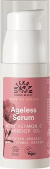 Urtekram Dare to Dream Ageless Seerumi, pullo ikääntymistä vastustavalle seerumille C-vitamiinilla, ruusunmarjaöljyllä ja vegaaneille sopivilla ainesosilla; etiketti korostaa luomusertifikaattia ja 100-prosenttisesti luonnollista alkuperää; pakkaus vaaleanpunainen kukkakuvioin; pullo sylinterimäinen mattapinnalla pumppuannostelijalla; etikettiteksti selkeällä groteskifontilla valkoisena ja hopeisena vaaleanpunaisella pohjalla; ei ihmisiä eikä käsiä näkyvissä, tausta yksinkertainen, tuote keskitettynä.