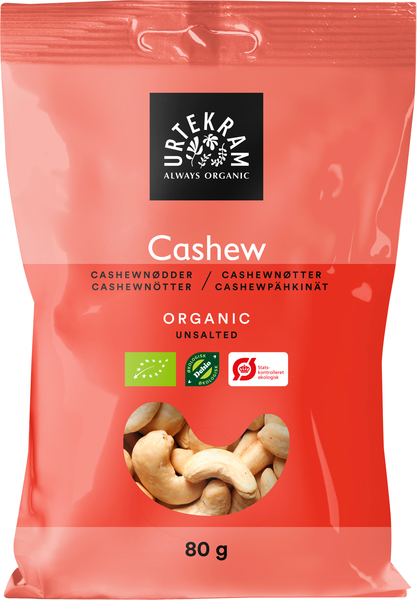 Urtekram Luomu Cashewpähkinä, punainen 80 g pussi merkittynä "Cashew", näyttää cashewpähkinät sisällä; mattapintainen joustava pakkaus kirkkaan ikkunaosuuden kanssa, joka näyttää sisällön; etiketissä groteskityppografia valkoisena ja vihreänä tekstinä "Organic" ja "Unsalted", sekä näkyvät luomusertifikaattilogot; tausta yksinkertainen, ei ihmisiä eikä käsiä näkyvissä.