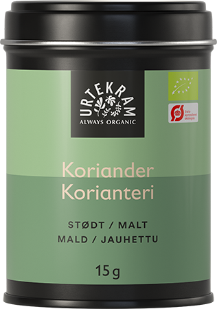 Urtekram Luomu Jauhettu Korianteri, vihreä sylinterimäinen metallitölkki mattapinnalla merkittynä "Urtekram Always Organic Koriander" usealla kielellä; pakkaus ilmoittaa 15 g jauhettua korianteria, luomusertifikaattilogot näkyvät etusivulla; huomattava groteskityppografia valkoisena ja mustana; tölkki yksin vaaleaa taustaa vasten tavanomaisessa tuotekuvassa.