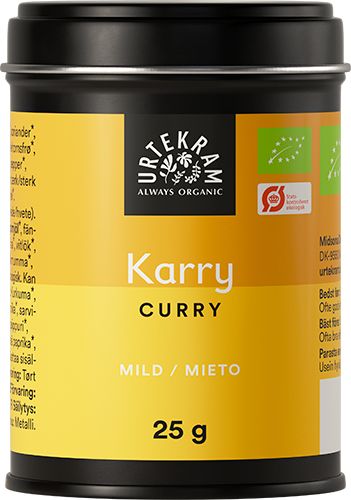 A 25g tin of Urtekram organic curry powder with a yellow label, featuring “Curry” and “Mild/Mieto” in white text, along with organic certification logos. The tin is cylindrical metal with a matte finish and has a silver lid. Label text uses simple sans-serif fonts, primarily in uppercase. Product stands upright on a plain, light background with no people or objects visible. Close-up shot centers the tin.