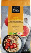 A bag of Urtekram Muesli Fruit & Nuts, 650g, made of matte-finish material. The front shows a bowl filled with muesli containing fruit and nuts, topped with strawberries; a spoon and sliced grapefruit halves are also pictured. Background is plain. Label displays product name in clear sans-serif lettering. No people or hands present. Medium shot focused on the package.
