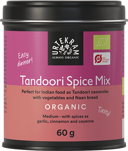 Urtekram Luomu Tandoori mausteseos, 60 g tölkki Urtekram Tandoori Spice Mixille merkittynä luomuksi; astia sylinterimäinen mattahopeisella kannella ja vaaleanpunais-oranssein paperipakkauksin; etiketti käyttää sekä lihavoitua että tavallista groteskifonttia; luettavassa tekstissä käyttökohteet intialaiselle ruoalle, pataruoille, naanleiville sekä ainesosat kuten valkosipuli, kaneli ja cayennepippuri; tuote valkoista taustaa vasten, ei ihmisiä eikä käsiä näkyvissä.