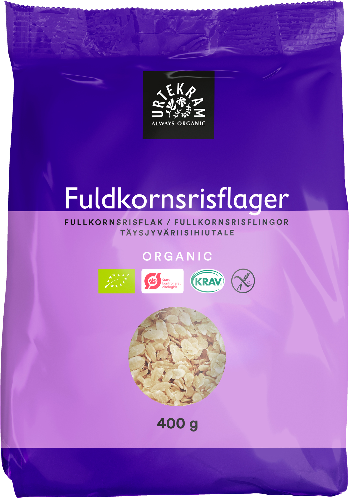 Urtekram Luomu Täysjyväriisihiutale, violetti 400 g pakkaus luomutäysjyväriisihiutaleille, sertifikaattimerkinnät ja kirkas ikkuna näyttää terveelliset hiutaleet sisällä; pakkaus suorakulmainen mattapinnalla; valkoinen ja musta groteskitypografia näyttää brändinimen, tuotekuvauksen ja painon; sertifikaattilogot etusivulla; tuote kuvattu yksinkertaista taustaa vasten, ei ihmisiä eikä käsiä näkyvissä.