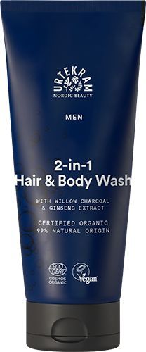 Urtekram Men 2in1 Hair & Body Wash, sininen tuubi hiusten ja vartalon pesuaineelle pajuhiilellä ja ginsenguutteella, luomu- ja vegaanimerkinnät, valmistettu 99-prosenttisesti luonnollisista ainesosista; tuubi pystyssä mattapinnalla ja pyöristetyllä korkilla, lihavoitua valkoista groteskitekstiä tuotenimelle, pienempää tekstiä lisätiedoille sekä etikettikuvakkeet näkyvissä; tausta valkoinen, ei ihmisiä eikä käsiä näkyvissä.