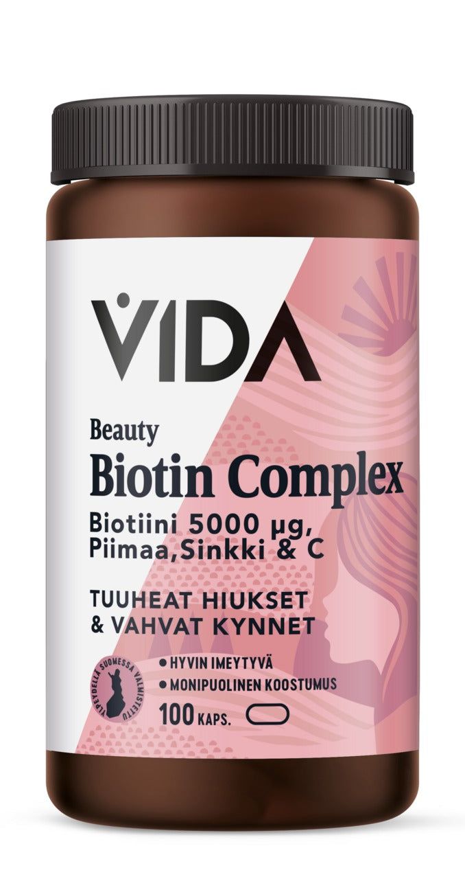 Vida Beauty Biotin Complex; ruskea muovipullo tekstillä "VIDA Beauty Biotin Complex", 5000 µg biotiinia, kalsiumia, sinkkiä ja C-vitamiinia; ravintolisä tukee paksua tukkaa ja vahvoja kynsiä; pullo sisältää 100 kapselia, etiketti pääosin valkoinen ja vaaleanpunainen; pullon pinta mattainen, lieriön muotoinen kierrekorkillinen; sans-serif-fontti hallitsee etikettiä; kuva näyttää vain tuotteen valkoista taustaa vasten, ei ihmisiä tai muita esineitä.