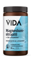 Ruskea muovipullo valkoisella kierrekorkilla, pinta mattainen. Etiketti on sininen ja valkoinen, lihavoidulla pääteviivattomalla tekstillä: VIDA Magnesiumsitraatti + B6-vitamiini. Siinä ilmoitetaan 90 kapselia ja luetellaan keskeiset ainesosat. Ihmisiä tai käsiä ei näy. Pelkistetty tausta, tuote keskitettynä kuvassa. Pullo tukee hermostoa ja lihaksia magnesiumin avulla.