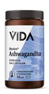 A brown plastic bottle of VIDA Shoden Ashwagandha capsules with a white and blue matte label. Label has a sans-serif font, includes Finnish text on stress management and high bioavailability, states 120 capsules. The bottle is cylindrical with a screw cap. Background is plain white; no people or other objects present.