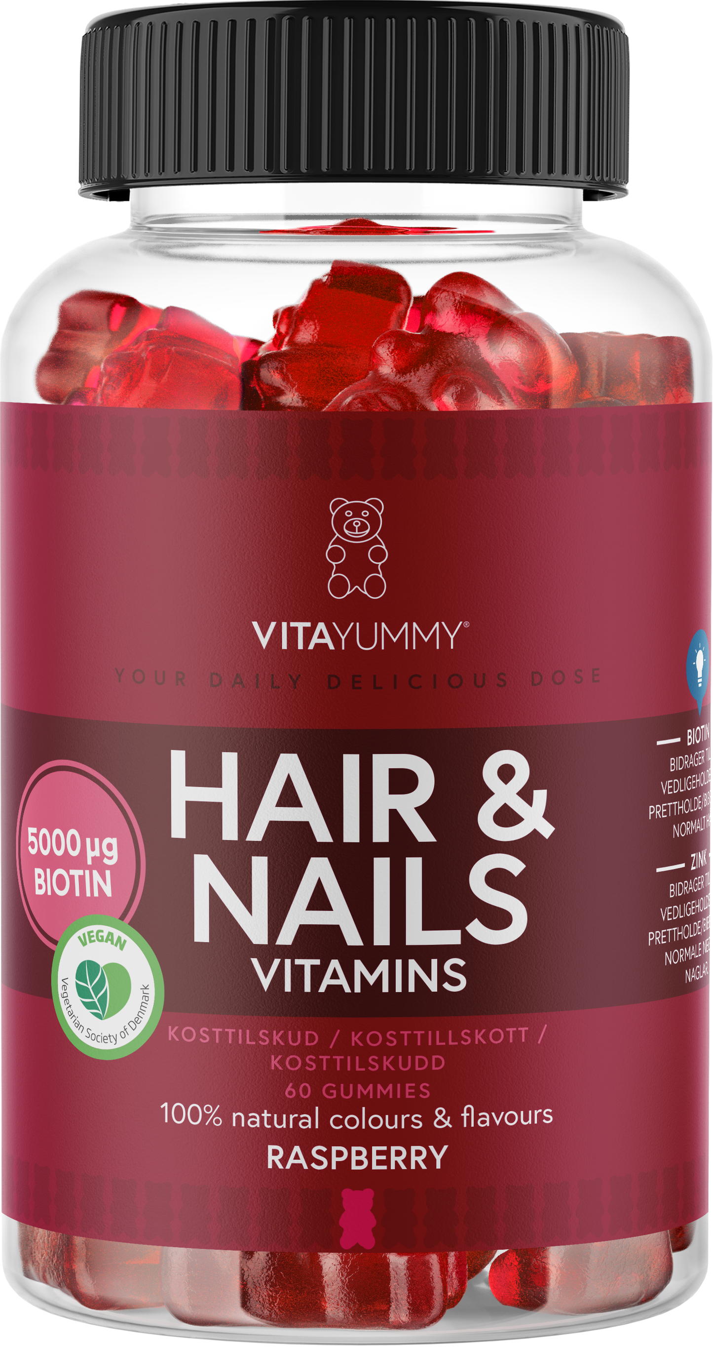VitaYummy Hair & Nails, maku Raspberry; kirkas pullo purutabletteja, maku vadelma; lieriömäinen muovipurkki kierrekannella; etiketissä lihavoitua vaaleanpunaista ja valkoista tekstiä mattatarralla; luettavissa 5000 µg biotiinia, vegaaniset ainesosat, 100 % luonnolliset värit ja maut, sekä 60 punaista purutablettia; neutraali tausta, ei ihmisiä tai käsiä.