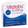 Vitatabs K2 200 µg + D3-vitamiini: rasia Vitatabs K2 200 µg + D3-vitamiini -ravintolisää sinisellä ja punaisella tekstillä, tuotetietoa suomeksi ja ruotsiksi; suorakulmainen kartonkirasia on mattapinnalla, sisältää 60 tablettia, merkitty "Valmistettu Suomessa" ja annostustietoa; groteskikirjasin; pakkaus kuvattu neutraalia taustaa vasten, ei ihmisiä näkyvissä.