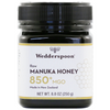 Wedderspoon Manuka-hunaja 850+ MGO; musta muovipurkki Wedderspoon Raw Manuka Honey 850+ MGO, 8,8 unssia (250 g), valkoinen etiketti hunajakennokuvioin ja selkeällä tekstillä, joka ilmoittaa Uuden-Seelannin alkuperän ja premium-laadun; etiketin fontit groteskia lihavoituna ja tavallisena painona; purkki mattapintainen, lieriömäinen muoto; tausta valkoinen ilman muita esineitä tai ihmisiä.