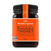 Wedderspoon Manuka-hunaja KF16 -purkki, 500 g; oranssi etiketti tuotetietoineen ja Non-GMO-tarkastusmerkki; muovipurkki sylinterimäinen mattamustalla kierrekannella; luettavassa tekstissä brändinimi ja tuotetyyppi lihavoidulla tekstausvapaalla fontilla; tausta valkoinen, ei ihmisiä tai käsiä näkyvissä.