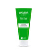 Green tube of Weleda Skin Food Face Care Nourishing Cleansing Balm features a white cap and product details in white and yellow text on the front. Tube has a matte finish, cylindrical shape with crimped end, all-plastic construction. Sans-serif typeface is centered. Background is plain white. No people or hands visible; close-up studio shot.