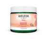 A jar of Weleda Mum Stretch Mark Body Butter, 150ml, featuring a silhouette of a pregnant woman on the label. The container is round with a white screw-on lid and blue body, displaying printed text in sans-serif font. Packaging is matte. The background is plain and well-lit. No people or hands are present in the shot. The text highlights its fast absorption and nourishing formula to help reduce stretch marks during pregnancy.
