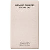 Whamisa Organic Flowers Facial Oil Deep Rich; suorakaiteen muotoinen beige pahvirasia mattapinnalla; etusivun etiketissä teksti ”Organic Flowers Facial Oil”, alaosassa lisäksi ”Organic 96%, 32ml / 1.0 fl.oz.”; kirjasintyyppi yksinkertainen ja groteski; rasian pinnoissa ei kuvituksia, vain tekstiä; tausta neutraali ja tasainen, ei näkyvää rekvisiittaa tai ihmisiä.