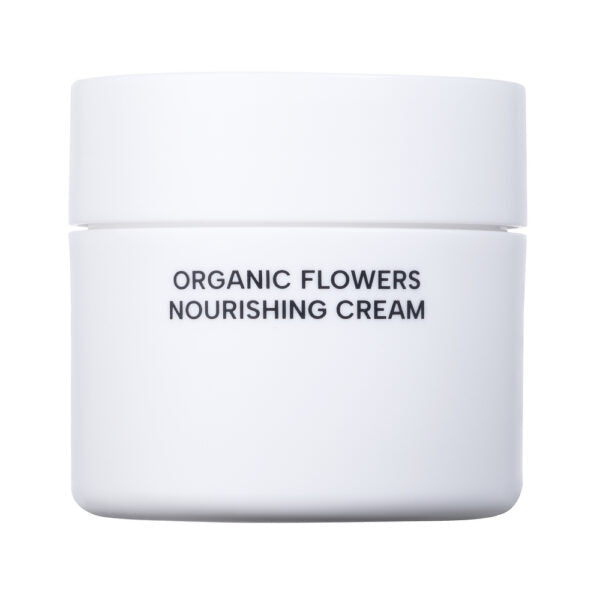 Whamisa Organic Flowers Nourishing Cream; valkoinen lieriömäinen purkki leveällä tasakannella ja mattapinnalla; etusivulla teksti ”ORGANIC FLOWERS NOURISHING CREAM” yksinkertaisella groteskityyppografialla; etikettisuunnittelu pelkistetty ilman lisäkuvitusta; tausta tasainen valkoinen, ei ihmisiä tai käsiä kuvassa.