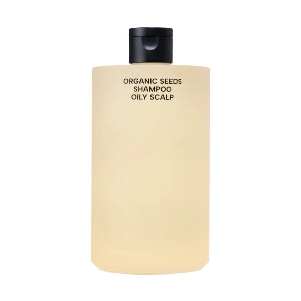 Whamisa Organic Seeds Shampoo Oily Scalp; beige pullo mustalla korkilla, etusivulla lihavoitu musta teksti ”Organic Seeds Shampoo Oily Scalp”, sisältää ravitsevia kasviuutteita, valkoista taustaa vasten; muovinen astia lieriömäinen hieman pyöristetyin olkaosin, mattapinta ja keskitetty etiketti; groteskifonttia pääasialliselle tuotenimelle; pullo pystyasennossa, ei ihmisiä tai esineitä näkyvissä.