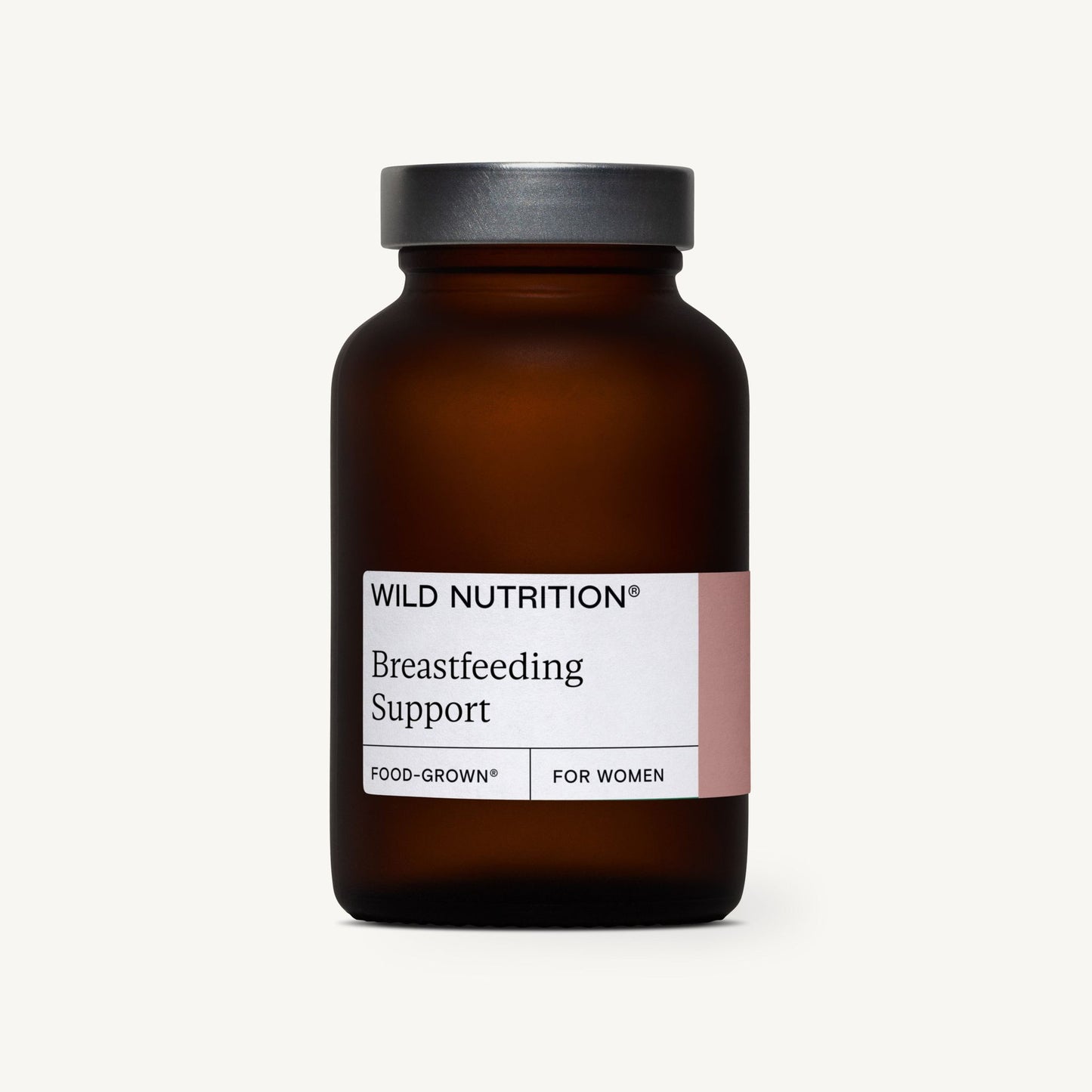 Wild Nutrition Breastfeeding Support; ruskea, lieriömäinen pullo, jossa musta korkki, valkoinen etiketti ja vaaleanpunainen korostusväri; mattapintainen; etiketissä groteskityyppistä tekstiä "Food-Grown nutrients for women"; tuote kuvattu yksin vaalealla, tasaisesti valaistulla taustalla.