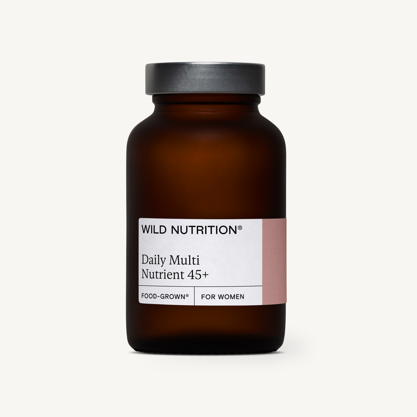 Wild Nutrition Daily Multi Nutrient 45+ Food-Grown for Women -lasipullo, ruskea pullo mustalla muovisella kierrekannella; pullo sylinterimäinen, valkoinen mattapintainen etiketti tekstausvapaalla fontilla; tausta yksinkertainen ja vaalea, mahdollisesti luonnonvalkoinen tai kermanvärinen; ei ihmisiä tai käsiä näkyvissä; tuote tarjoaa päivittäisen monipuolisen ravintolisän naisille.