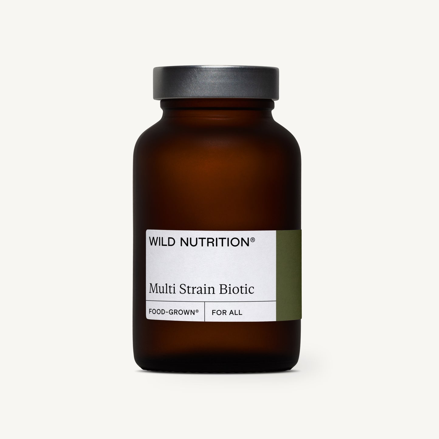 Wild Nutrition Multi Strain Biotic; ruskea lasipullo mustalla korkilla vaaleaa yksiväristä taustaa vasten, esittelee premium-monikantavalmisteen; pullo mattapintainen ja sylinterimäinen; etiketissä selkeä groteskityyppi mustin ja harmain tekstein; ei ihmisiä eikä käsiä näkyvissä, tuote kuvattu suoraan edestä silmän korkeudelta.
