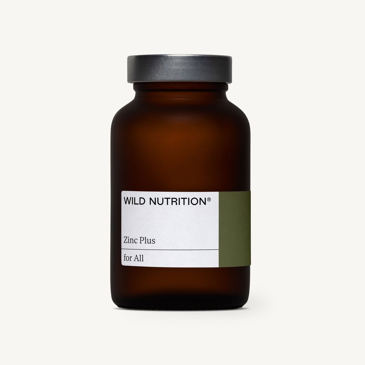 WILD NUTRITION Zinc Plus for All -pullo, ruskea lasipullo harmaalla kannella, valkoinen ja vihreä etiketti, kuvattu vaaleaa taustaa vasten; pullo sylinterimäinen mattapinnalla, sileä kierrekorkki; etiketissä selkeää tekstausvapaata typografiaa mustalla ja vihreällä; ei ihmisiä tai käsiä näkyvissä suoraviivaisessa tuotekuvassa.