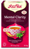 YogiTea Luomu Mental Clarity Tee; pakkaus, kuvassa teekuppi, ginsengiä ja raikasta minttua; kofeiiniton luomutee sisältää 17 teepussia; pakkaus on pääosin punainen ja pinkki, suorakulmainen ja mattapintainen; etiketissä valko-kultaista groteskitekstiä; ei ihmisiä tai käsiä näkyvissä, kuvassa näkyy vain laatikon etuosa yksivärisellä taustalla.