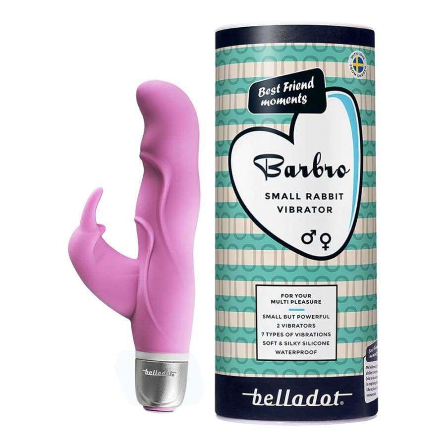 Belladot Barbro Small Rabbit Vibrator: vaaleanpunainen silikoninen vibraattori mattapinnalla seisoo pystyssä sylinterimäisen pakkauksensa vieressä; pakkauksessa turkoosi-valkoinen kuviointi ja selkeä teksti "Barbro Small Rabbit Vibrator by Belladot"; molemmat esineet ovat esillä tasaisella pinnalla, ei ihmisiä tai käsiä näkyvissä; kuva on tasaisesti valaistu neutraalia taustaa vasten.