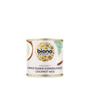 Biona Organic Sweetened Condensed Coconut Milk -tölkki; kookospalmuja ja lehtiä esittäviä eloisia kuvituksia vaalealla taustalla; lieriömäinen tölkki mattapinnalla ja metallikannella; brändi- ja tuotenimi suurella, lihavoidulla groteskifontilla; vaalea tausta, ei ihmisiä tai muita esineitä; tuote kuvattu suoraan edestä.